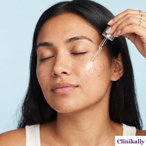 A woman applying skincare serum drops onto her cheek