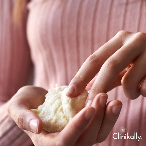 Hand scooping raw shea butter for skincare