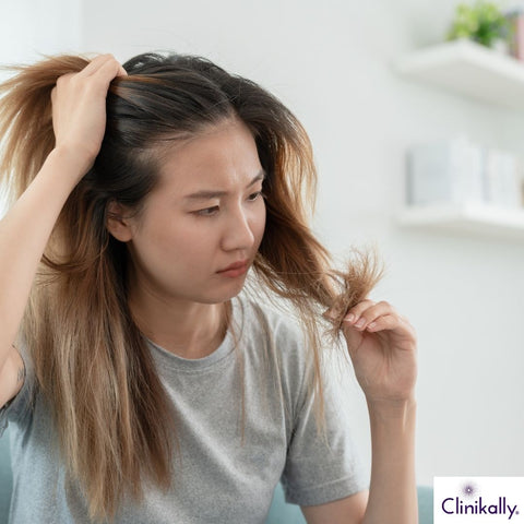 Woman examining damaged thinning hair