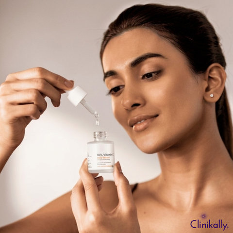 Woman holding Vitamin C serum dropper bottle